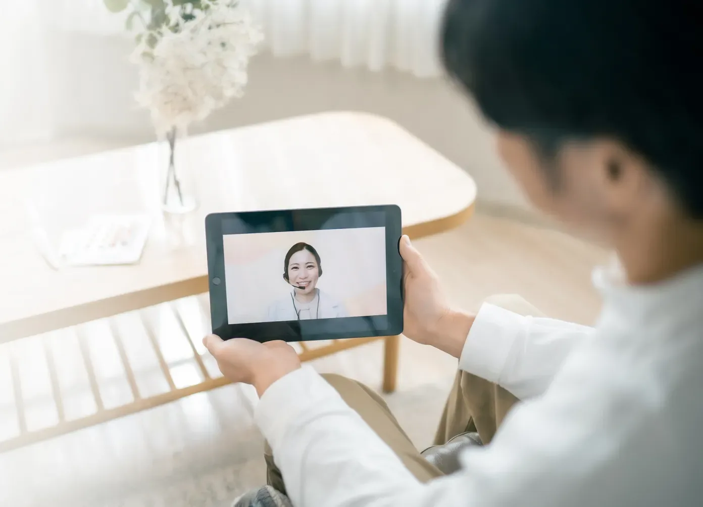 タブレット越しに医師のオンライン診療を受けている様子